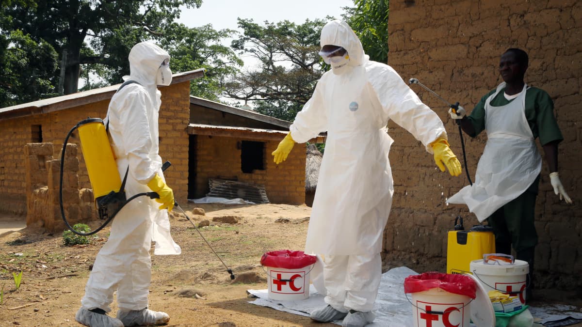 Ebolaan kuolleiden ruumiita kuljettaneita vapaaehtoistyöntekijöitä puhdistettiin kloorilla Koangossa, Guineassa huhtikuussa 2014. 
