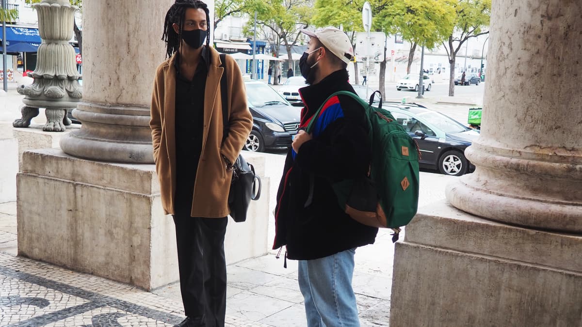 Kaksi miestä seisoo kadulla Lissabonissa.