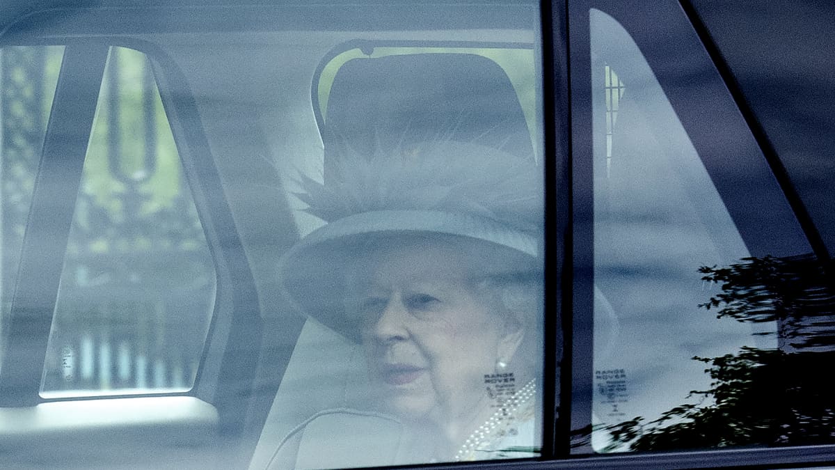 Kuningatar Elizabeth istumassa autossa matkalla Yhdistyneen kuningaskunnan parlamentin uuden istuntokauden alkamisseremoniaan. 