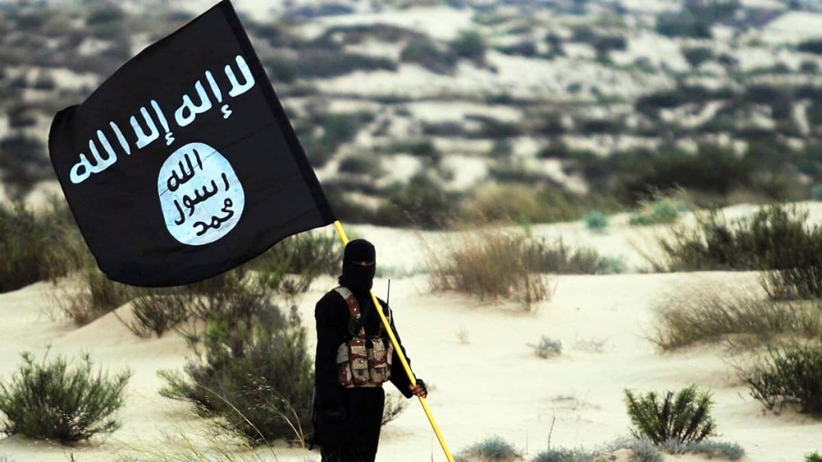 Ihminen pitelee terroristijärjestö Isisin lippua.