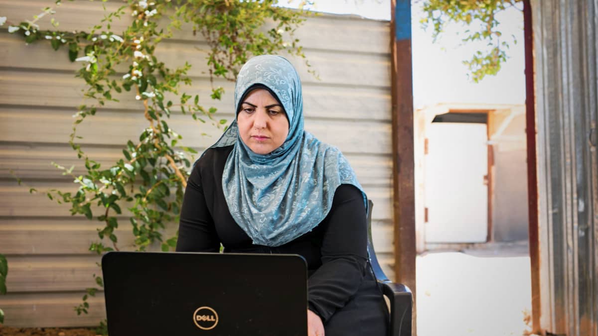 Rana Ibrahim Alsees käyttää kannettavaa tietokonetta Zaatarin pakolaisleirillä Jordaniassa. 