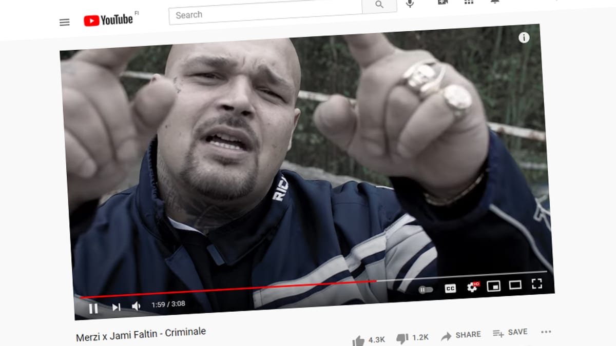 Kuvakaappaus musiikkivideosta YouTubesta. Kuvassa mieshenkilö osoittelee sormillaan ylöspäin.