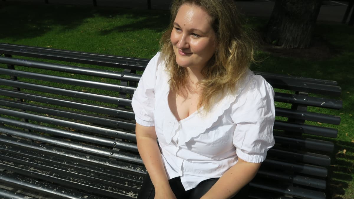 Vivi Mikkonen istuu penkillä puistossa.