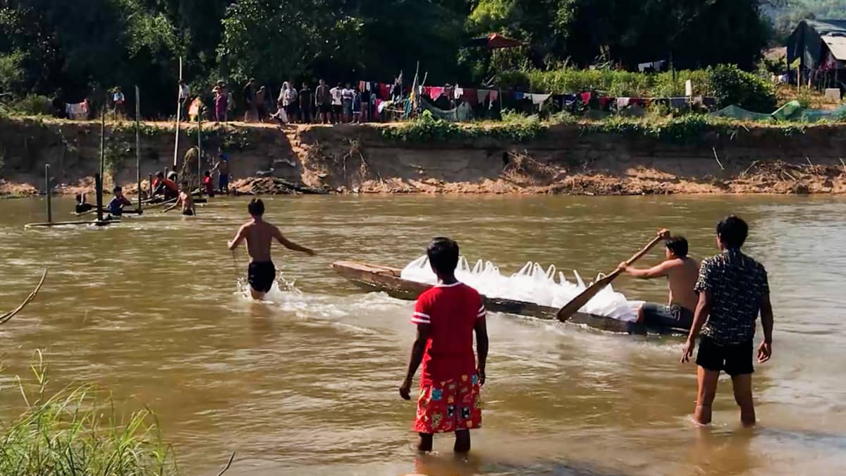 Myanmarista pakenevat saavat rajajoen yli ruokaa maanmiehiltään Thaimaasta.