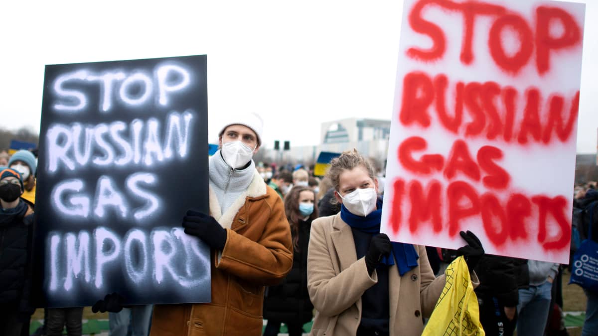 Mielenosoittajia kylttien kanssa, joissa vaaditaan lopettamaan kaasun tuonti Venäjältä.