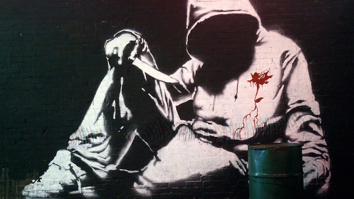 Alikulkutunneliin tehty Banksyn graffitimaalaus, jossa on veitseä pitelevä hupparimies.
