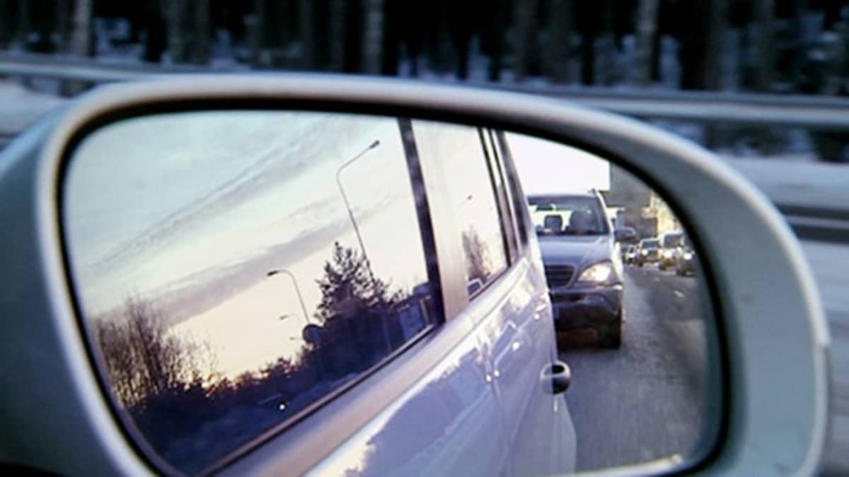 Liikenneruuhka heijastuu auton taustapeilistä.