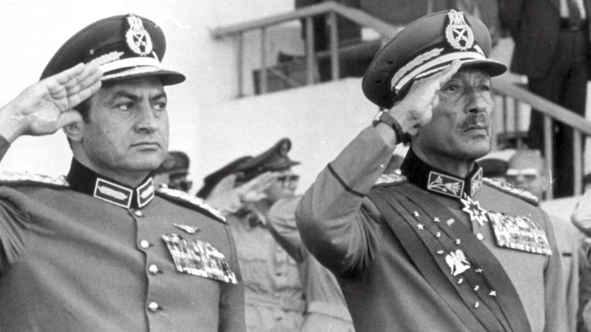Hosni Mubarak ja Anwar Sadat sotilasuniformuissa kädet lipassa vuonna 1981.