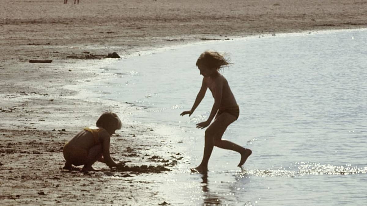 Kaksi lasta leikki vedenrajassa
