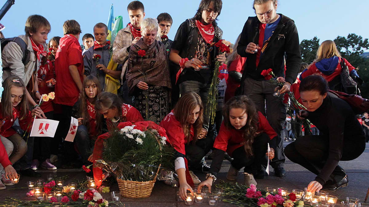 Venäläiset nuoret laskevat kukkia ja kynttilöitä Tuntemattoman sotilaan haudalle.