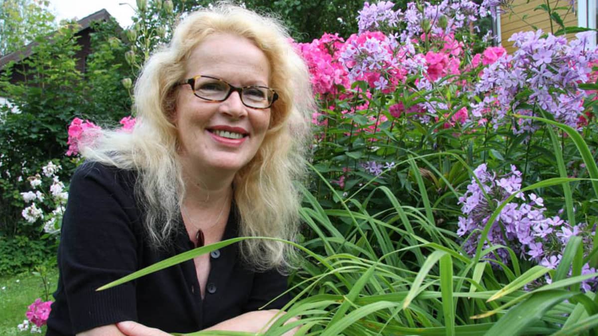 Riitta Jalonen kotipihansa kukkien keskellä