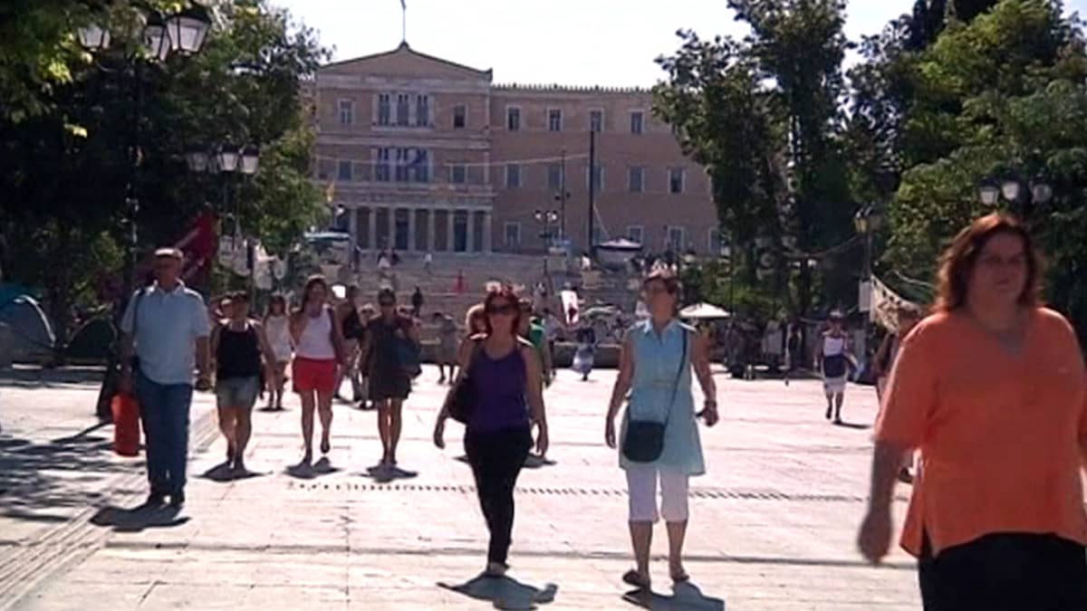 Ihmisiä kävelee Ateenan Syntagma-aukiolla.