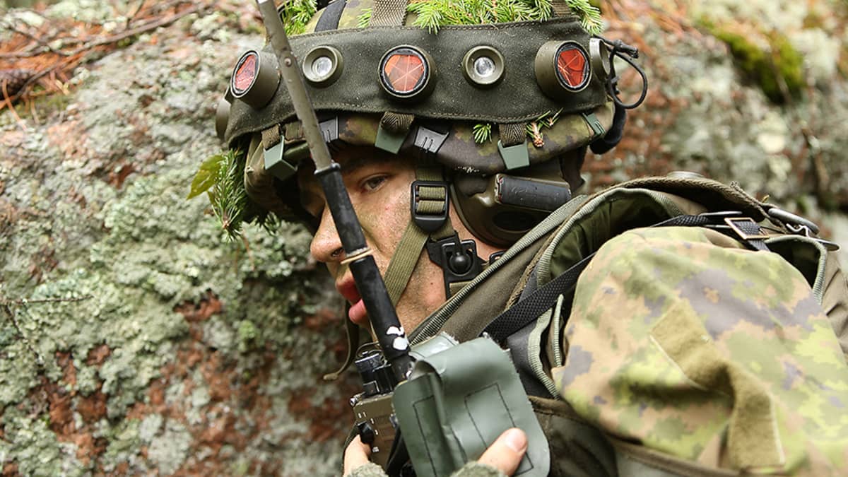 Varusmies sotaharjoitus Pyörremyrskyssä yllään taistelijan simulaattori ja viestivälineenä kenttäradio LV 141.