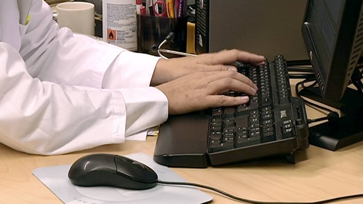 Lääkäri syöttää tietokoneelle potilaan tietoja järjestelmään.