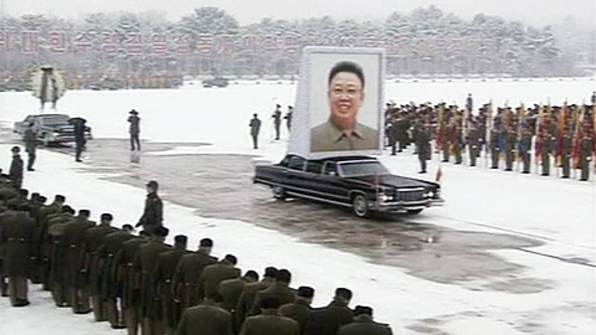 Suurta Kim Jong-ilin kuvaa kuljettava auto kulkee sotilasrivistöjen läpi.