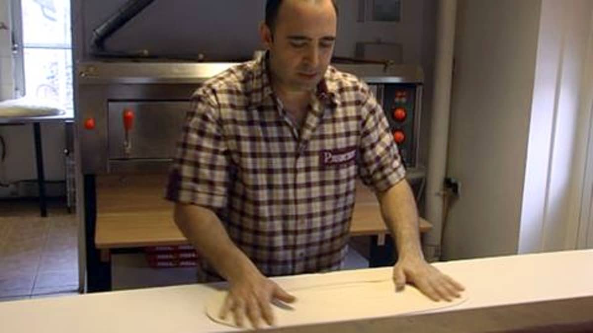 Ravintoloitsija Erkan Uzun pyöräyttää pizzapohjan