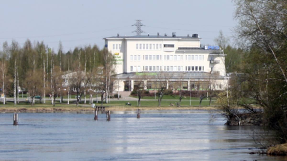 Pohjois-Karjalan osuuskaupan valkea päärakennus Pielisjoen rannalla.