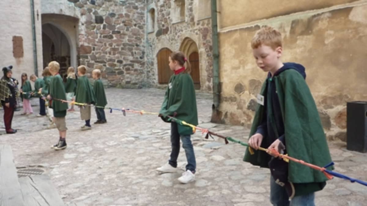 Velho-oppilaat mittaavat, kuinka vanha Turun linna on.