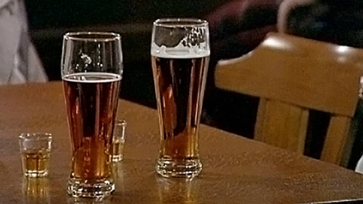 Kaksi oluttuoppia ja kaksi viskipaukkua ravintolan pöydällä