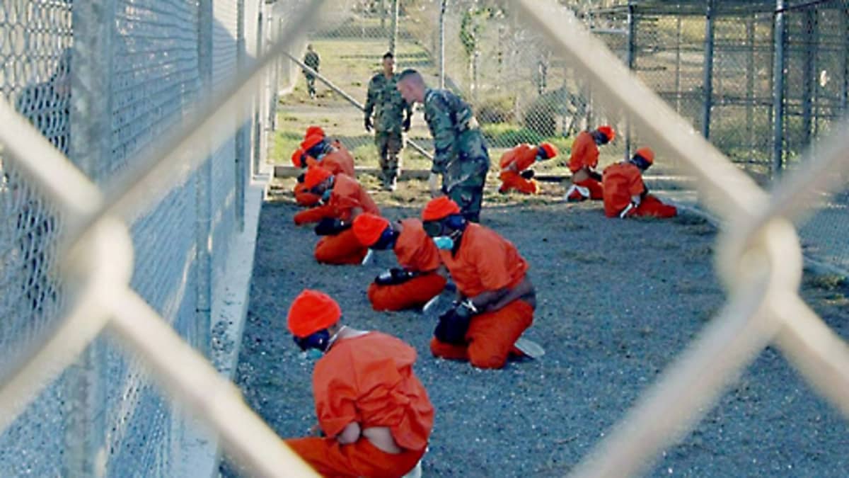 Vankeja sotilaspoliisien valvonnassa Guantanamossa tammikuussa 2002.