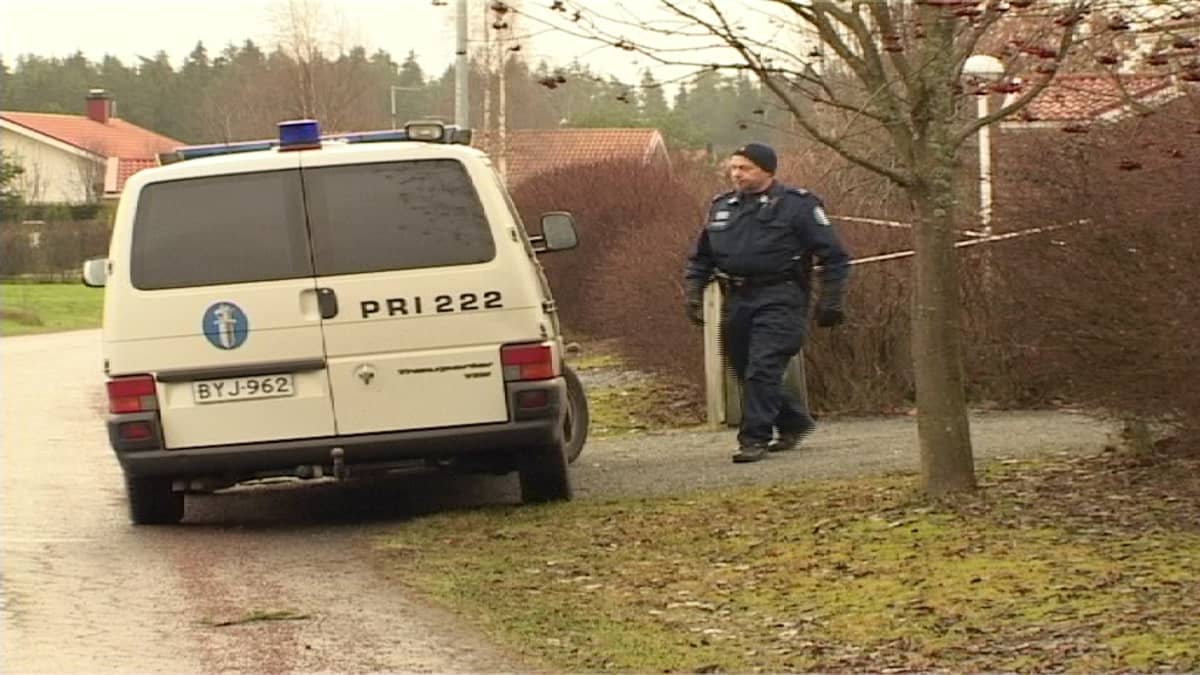 Tähtisentie 1.12.2006. Poliisi kävelee surmatalon pihamaalla.