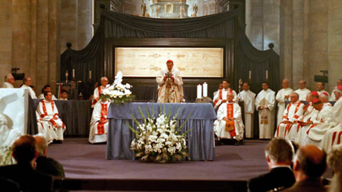 Messutilaisuus Torinon katedraalissa. Käärinliina on esillä pyhäinjäännösalttarissa messua pitävän papin takana.