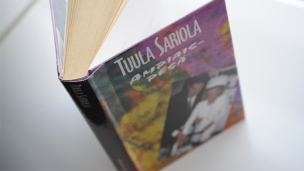 Kuva Tuula Sariolan Ampiaispesä-dekkarin kannesta. Kirja on kuvattu ylhäältä päin valkoisen tason päällä.