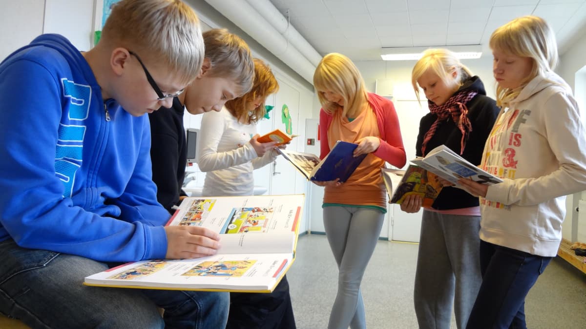 Melalahden koulun 6-luokkalaiset lukevat koulukirjaston kirjoja.