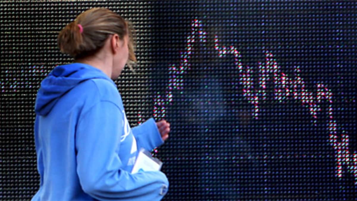 Nainen tarkastelee pörssikäyrää Lontoon pörssissä