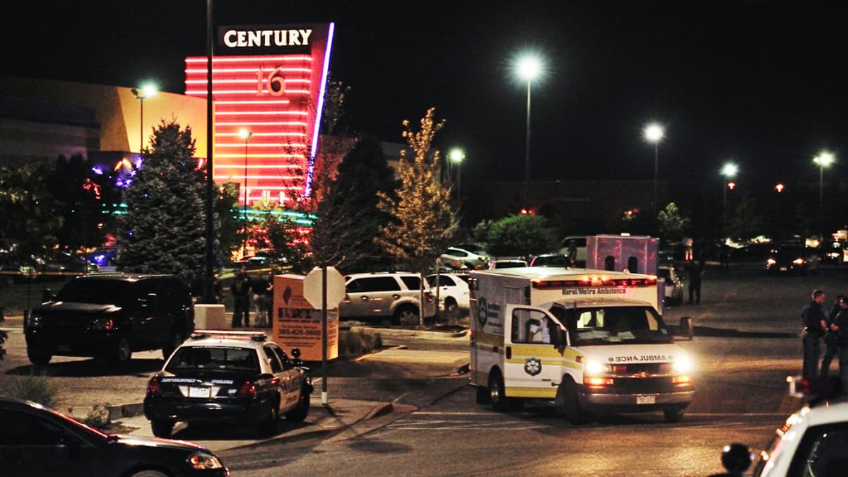 Ambulanssi ja poliisiautoja elokuvateatterin edessä.