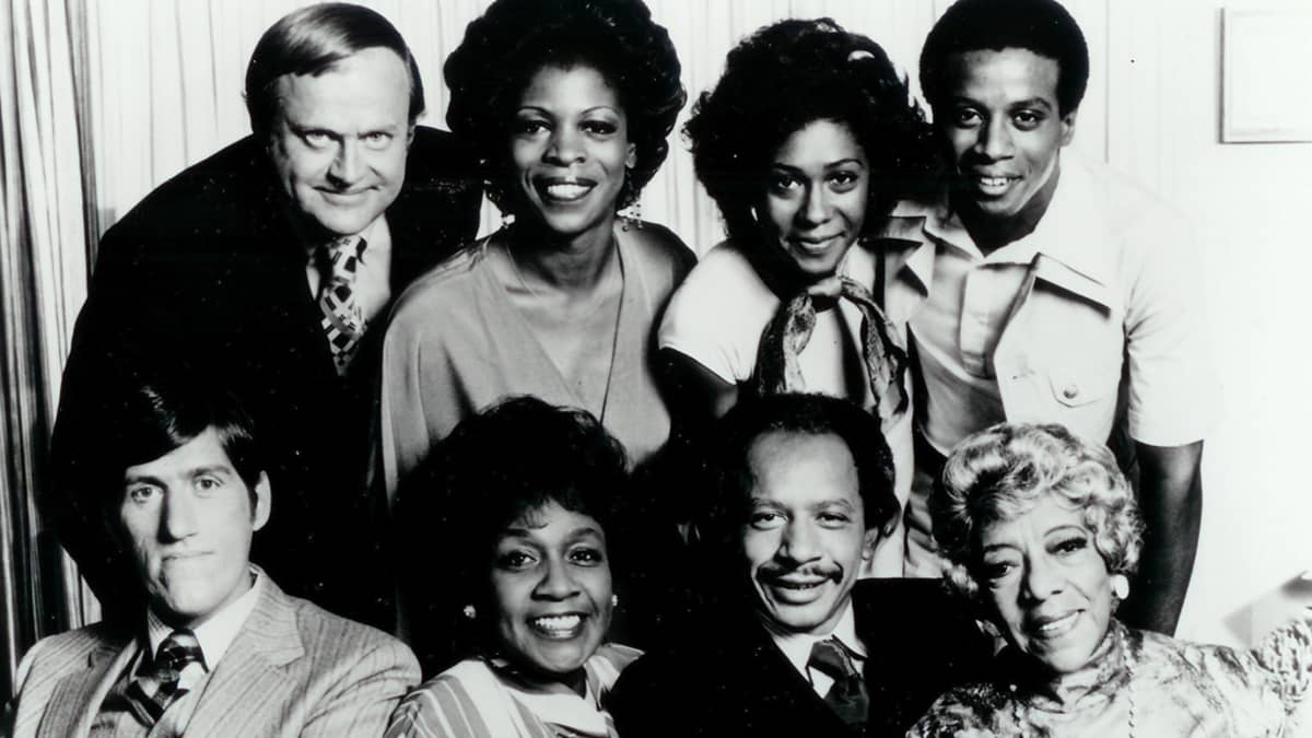 The Jefferssons televisiosarjan näyttelijät yhteiskuvassa. Sherman Hemsley alarivissä toinen oikealta.