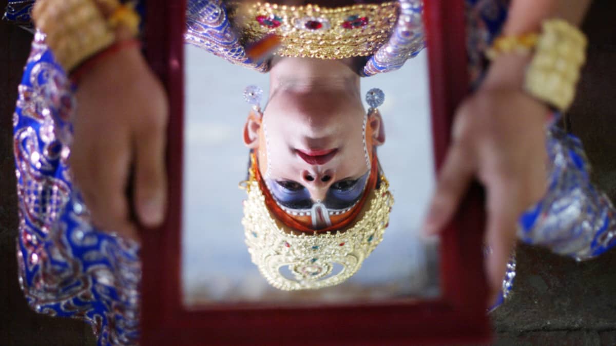 Hindujumalaksi meikattu lapsi katsoo peiliin ennen osallistumistaan Hindujen Janmashtami-juhlaan Intian Amritsarissa 