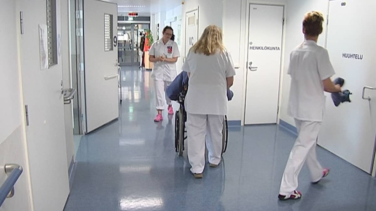 Kolme sairaanhoitajaa Kaupin sairaalan käytävällä.