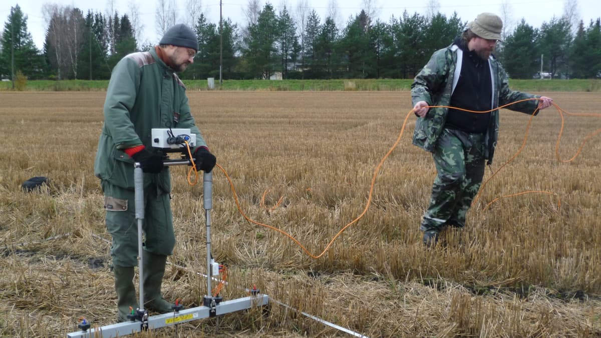 Provessori Mika Lavento ja argeologian opettaja Wesa Perttola mittaavat maavastusmittarilla Kauttualaista peltoa
