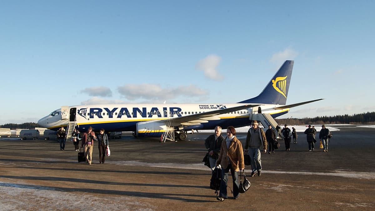 Matkustajia ja Ryanairin kone Tampere-Pirkkalan lentokentällä.