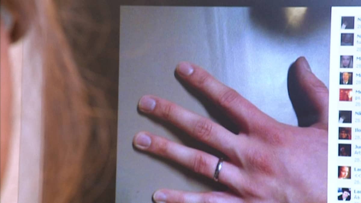Tietokoneruudulla näkyy kuva vasemmasta kädestä, jonka nimettömässä on sormus.