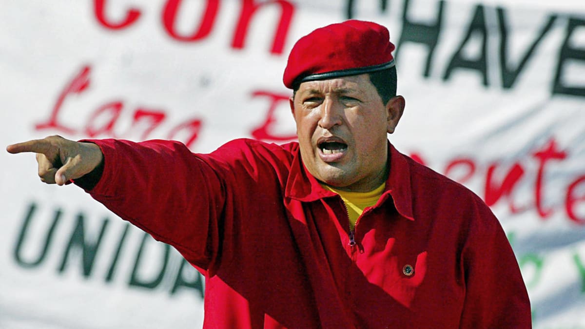 Hugo Chávez banderollin edessä.