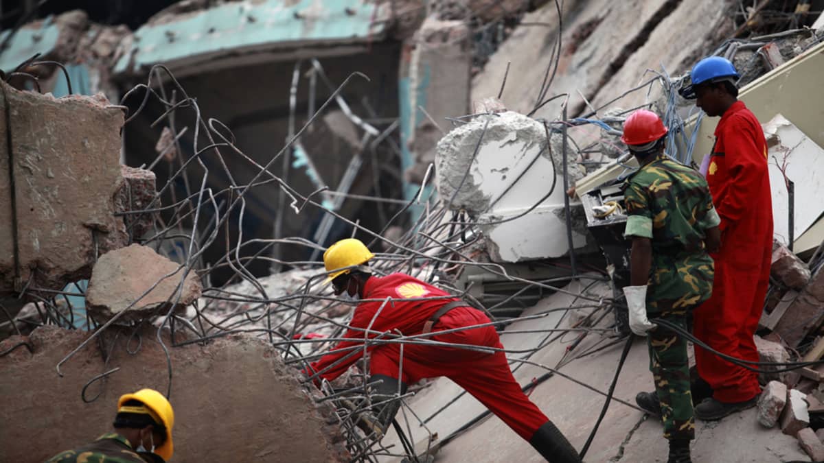 Pelastustyöntekijät etsivät eloonjääneitä romahtaneen rakennuksen raunioista Dhakassa.