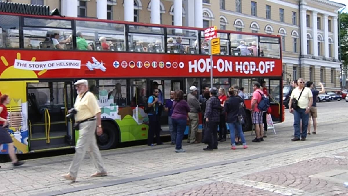 Matkailijoita kiertoajelubussin edustalla Helsingin Senaatintorilla kesäkuussa 2013.