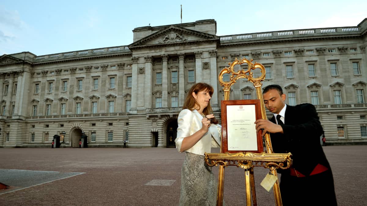 Kuningattaren lehdistösihteeri Ailsa Anderson ja hovimestari Badar Azim asettivat Buckinghamin palatsin edustalle ilmoituksen poikavauvan syntymästä 22. heinäkuuta.