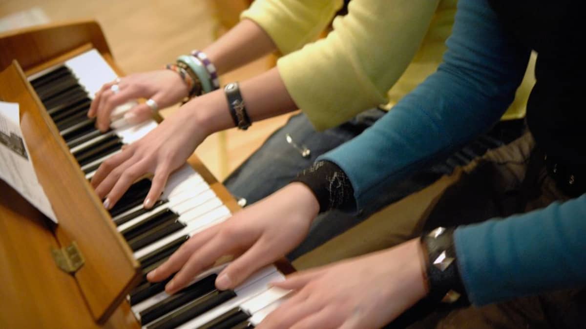 Musiikkiluokkalaiset tuntevat suurempaa yhteenkuuluvuutta kuin tavallisessa koululuokassa opiskelevat. Kaksi tyttöä soittavat yhdessä pianoa. 