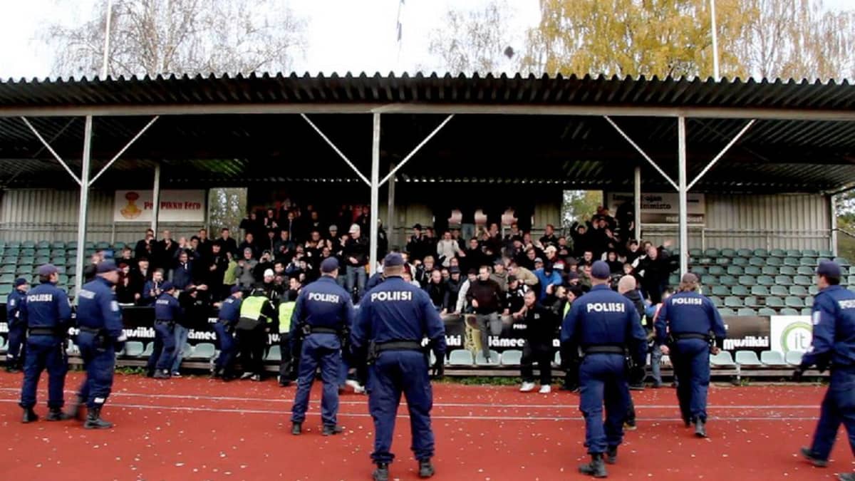 FC Lahden kannattajia katsomossa, poliiseja kentällä. 