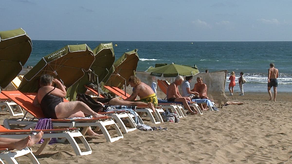 Turisteja uimarannalla Playa del Inglesissä Kanariansaarilla.