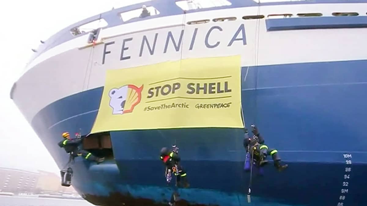 Greenpeacen aktivistit ripustamassa Shellin vastaista banderollia jäänmurtaja Fennican kylkeen Helsingin Katajanokalla.