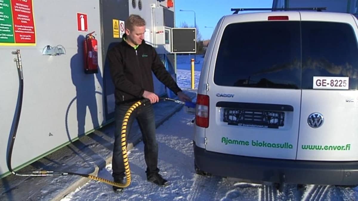 Mies tankkaa kaasuautoa