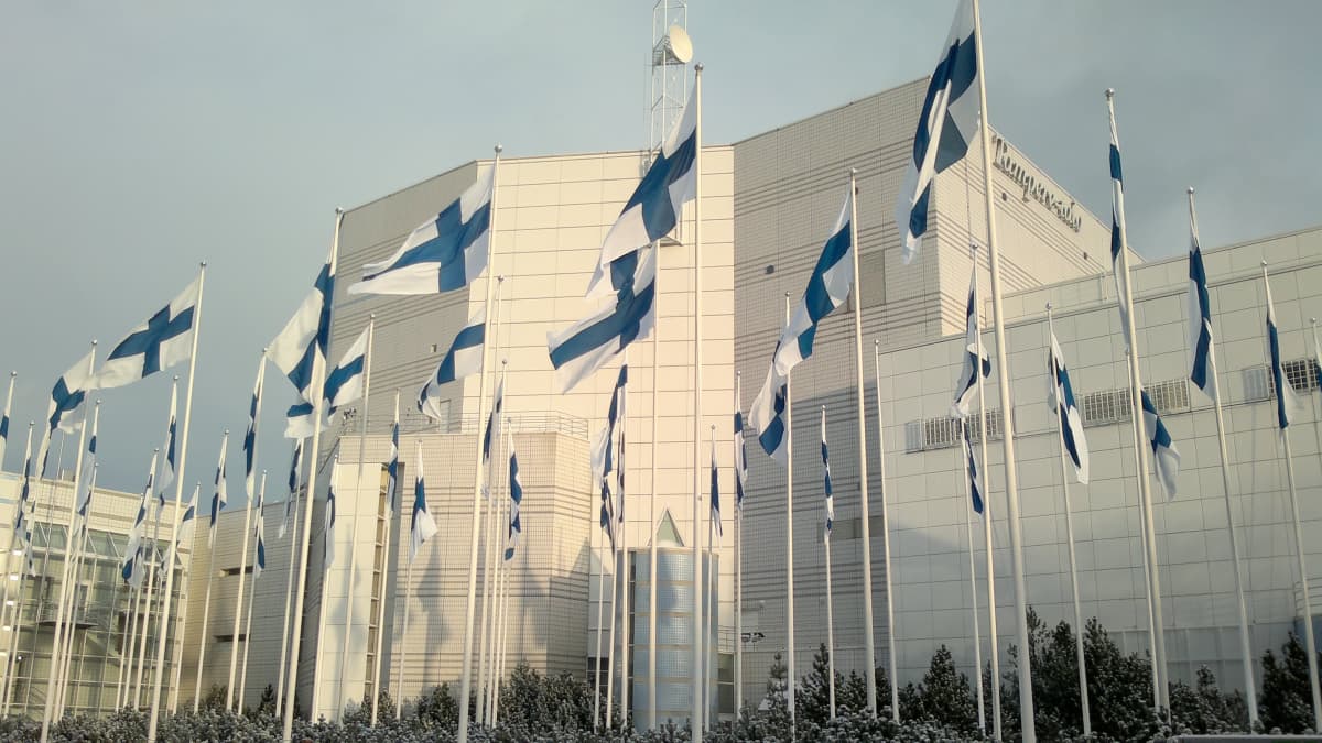 Kymmenet Suomen liput liehuvat Tampere-talon edustalla.