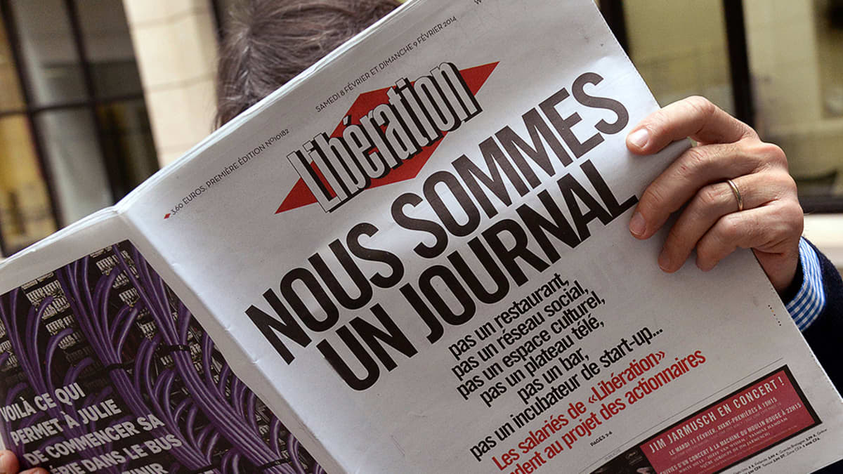 Mies lukee Libération-sanomalehteä.