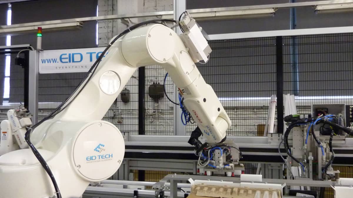 Valkoinen robotti käsittelee led-valoputkia Valtavalon Kajaanin-tehtaalla