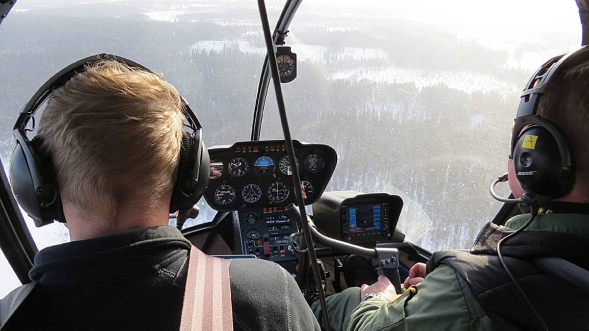 Tervolan riistanhoitoyhdistyksen toiminnanohjaaja Kari Kokkonen ja lentäjä Keijo Korkiakoski tähystävät hirviä helikopterista.
