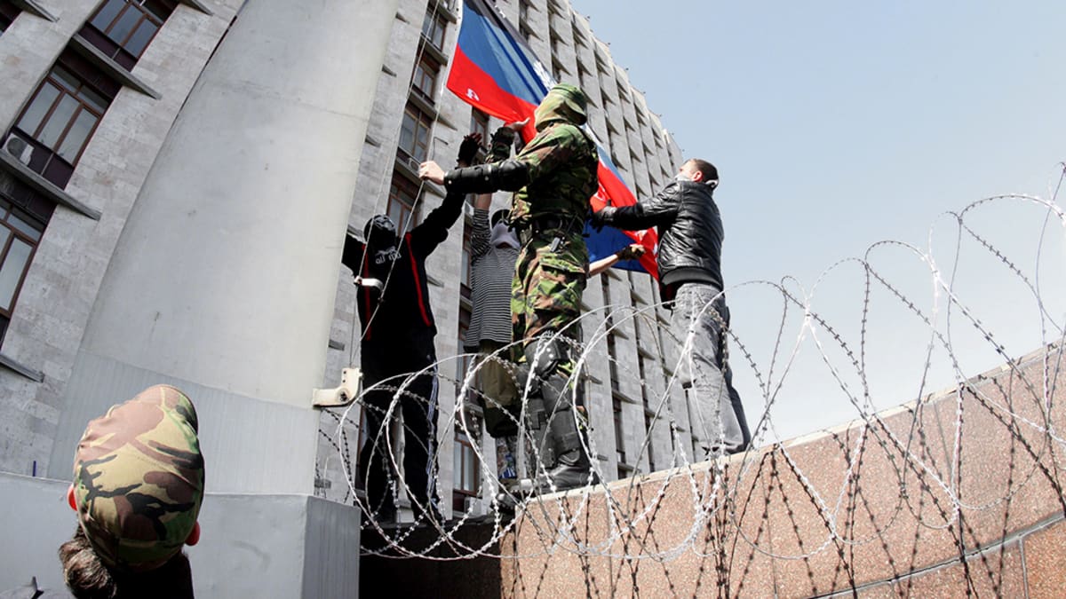 Venäläismieliset nostavat Venäjän lipun salkoon hallintorakennuksen edustalla Donetskissa.